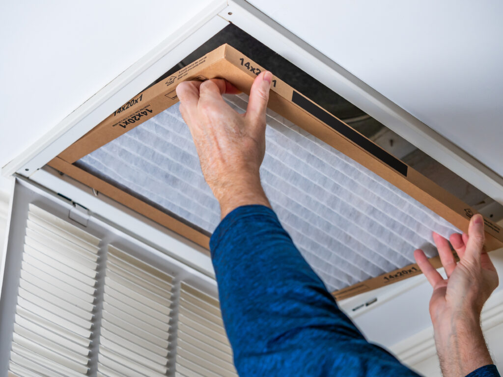 HVAC technician replacing a home air filter in Manhattan Beach